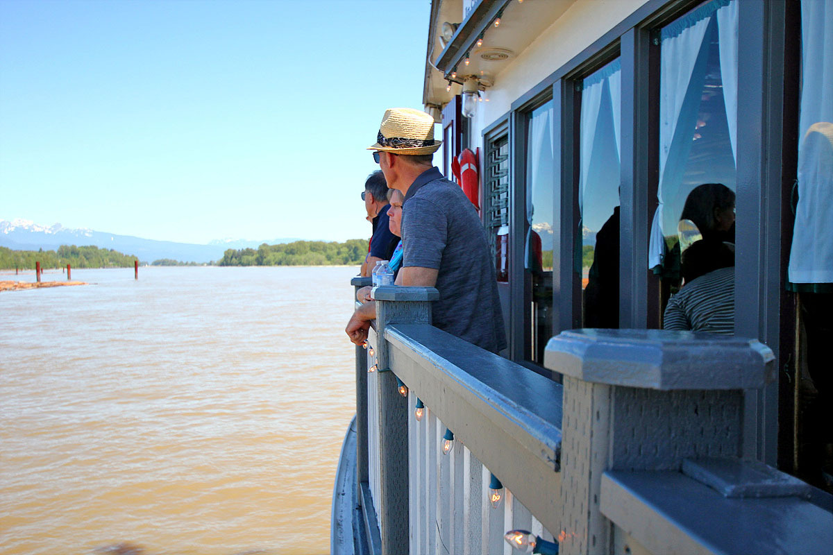 Guests enjoying the deck railing with a river view